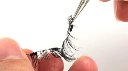 A lash strip held between fingers